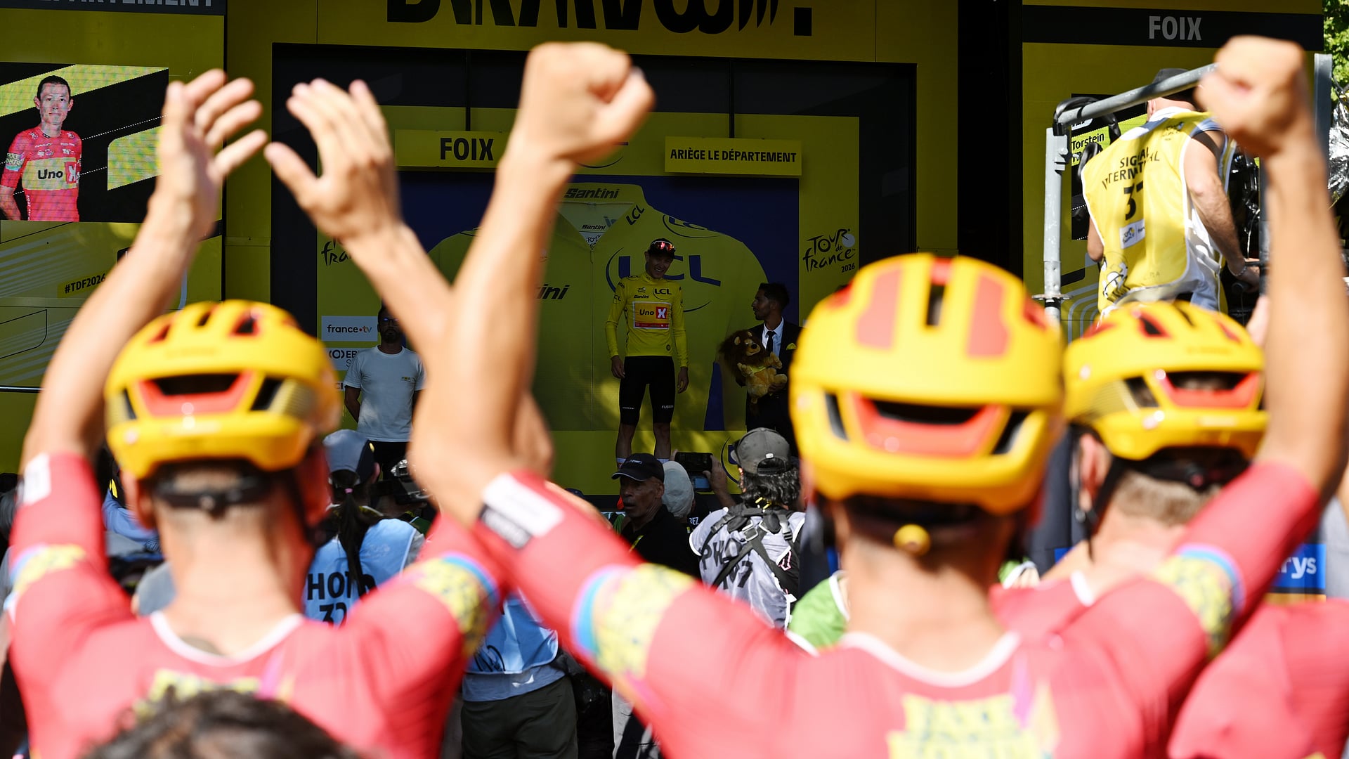 Torstein Træen celebrates on the podium in the yellow jersey after stage four of the 2026 Tour de France in Foix